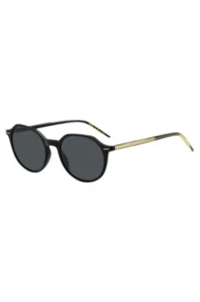 Gafas de sol de acetato negro con detalle en tono dorado de la marca